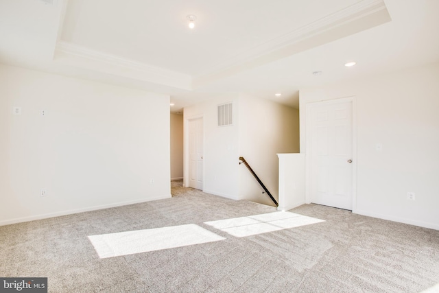 carpeted spare room featuring a tray ceiling