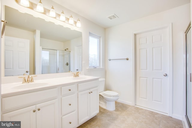 bathroom featuring vanity, a shower with shower door, and toilet