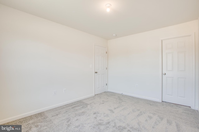 spare room featuring light carpet