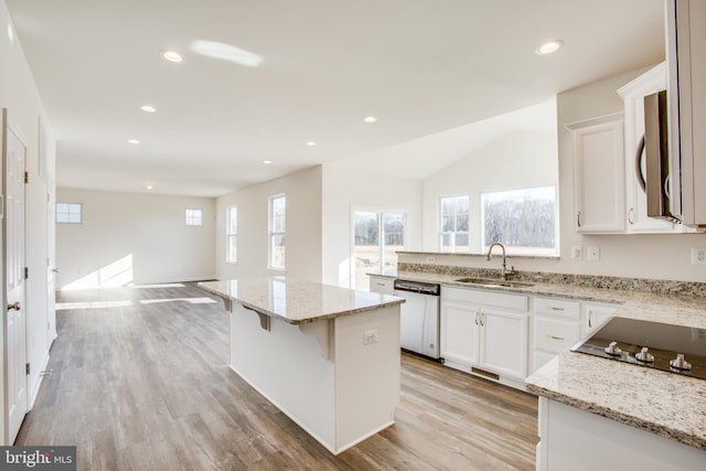 kitchen with sink, stainless steel dishwasher, light stone countertops, a kitchen island, and white cabinetry