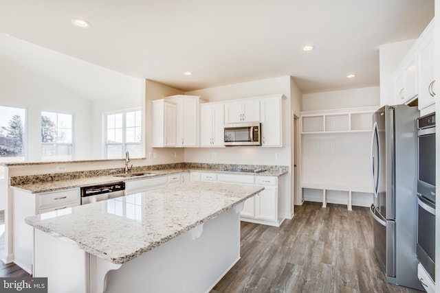 kitchen featuring white cabinets, a center island, light wood-type flooring, and appliances with stainless steel finishes