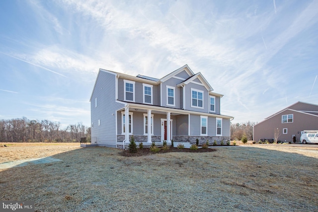 view of front of house featuring a front lawn, a porch, and solar panels