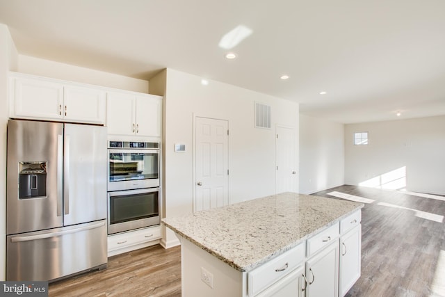 kitchen with white cabinetry, light hardwood / wood-style flooring, light stone counters, and appliances with stainless steel finishes