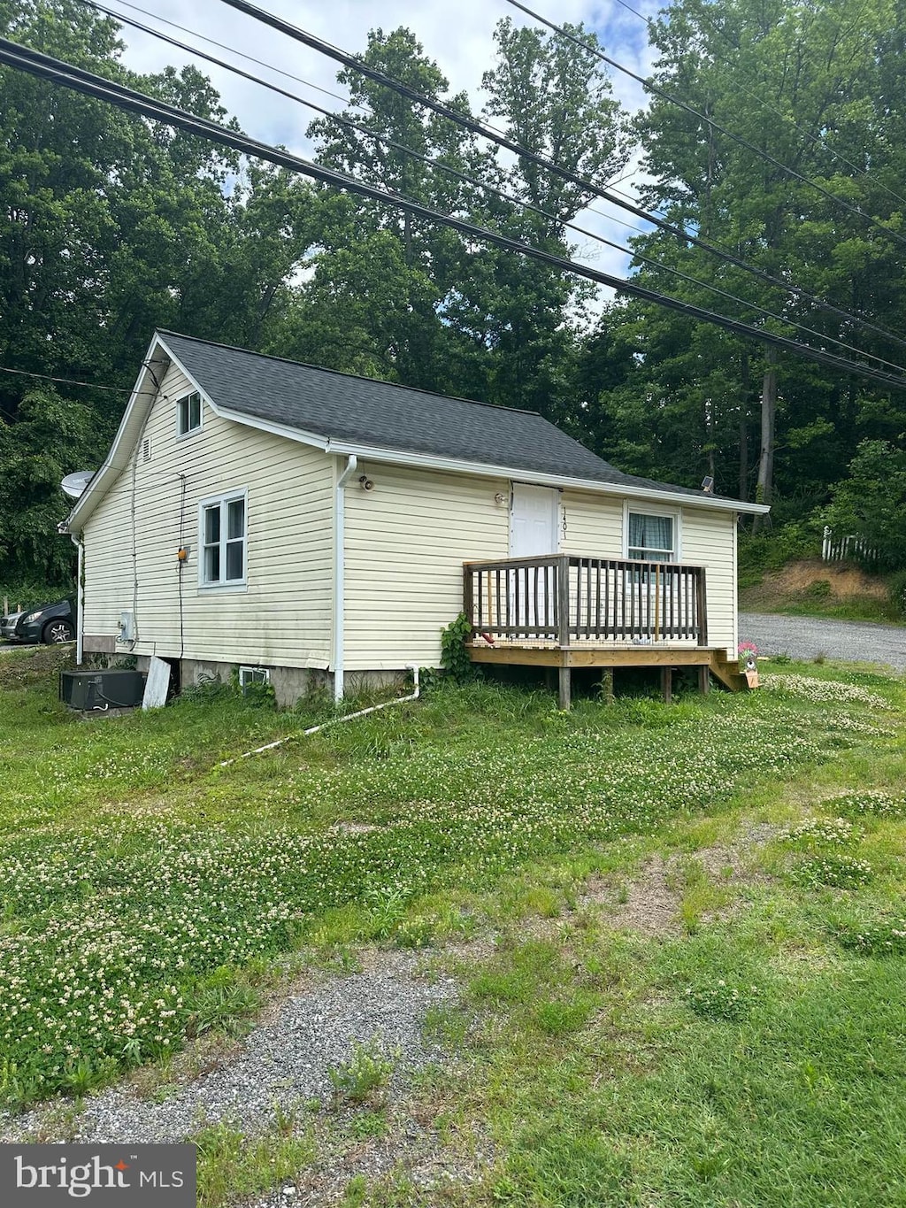 exterior space featuring a front yard and a wooden deck