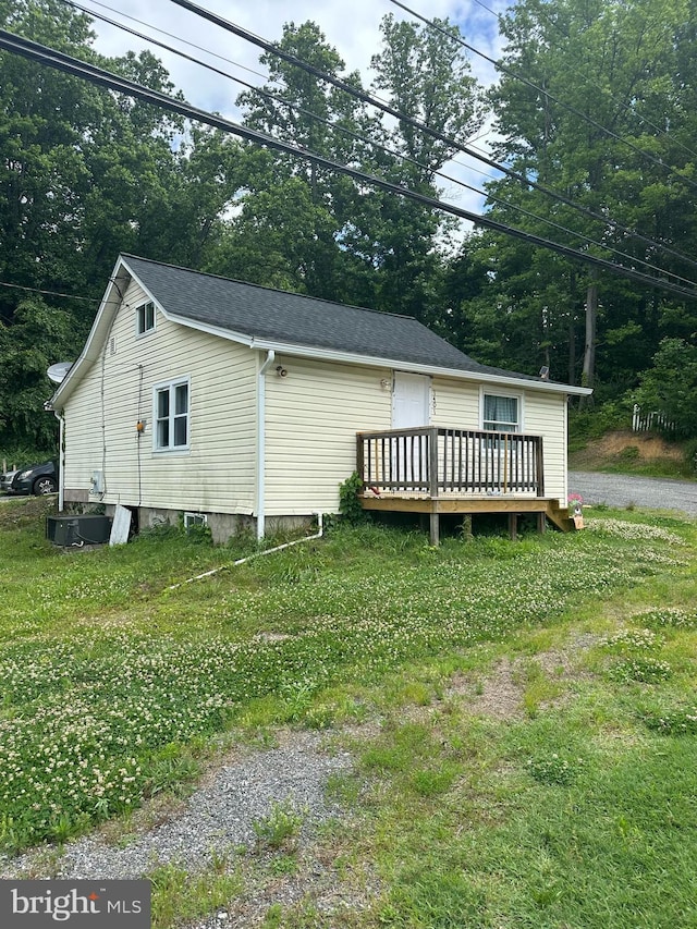 exterior space featuring a front yard and a wooden deck