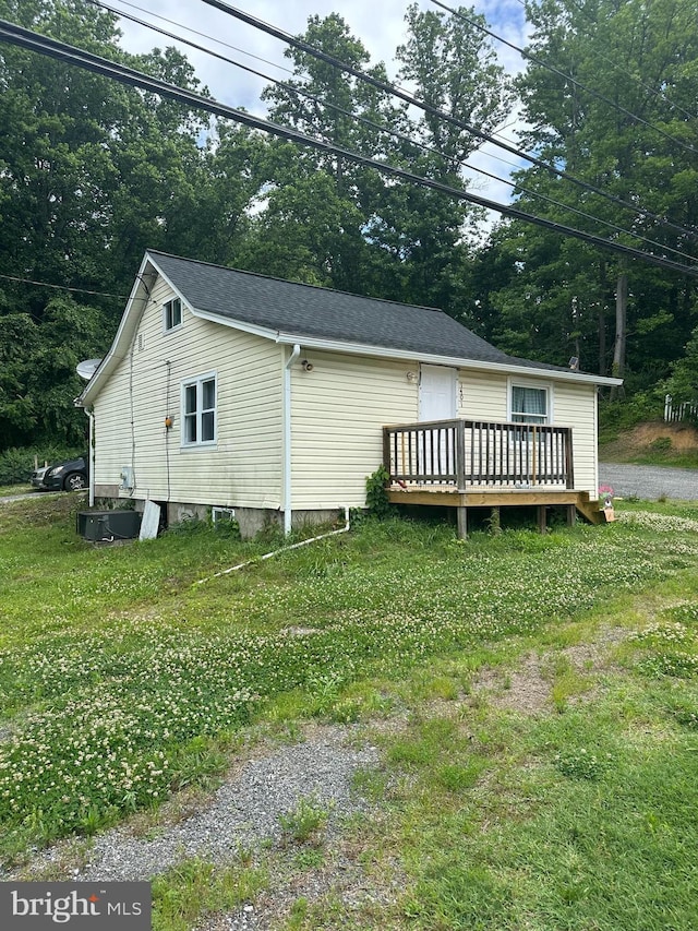 view of home's exterior featuring a lawn and a wooden deck