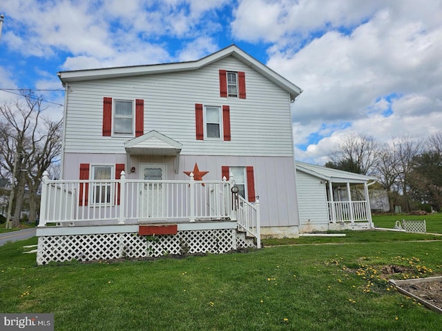 rear view of house featuring a lawn