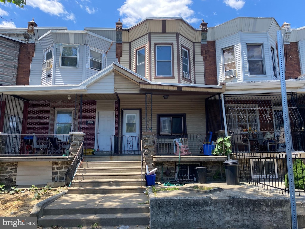 townhome / multi-family property with a porch and cooling unit