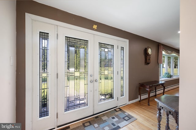 doorway with french doors, a baseboard radiator, and light hardwood / wood-style floors