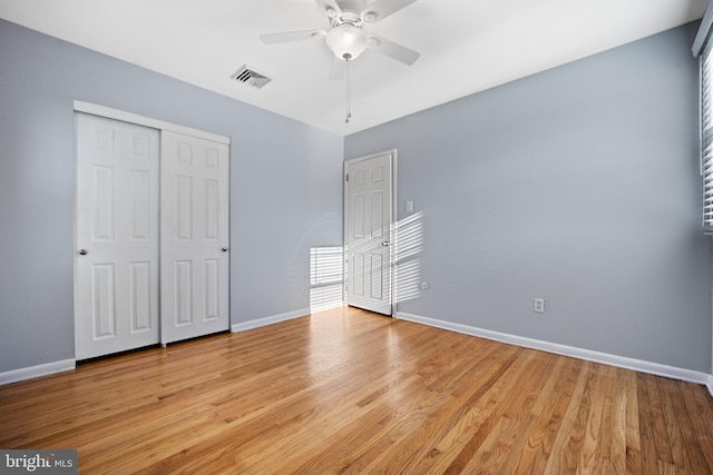 unfurnished bedroom with ceiling fan, a closet, and light hardwood / wood-style flooring