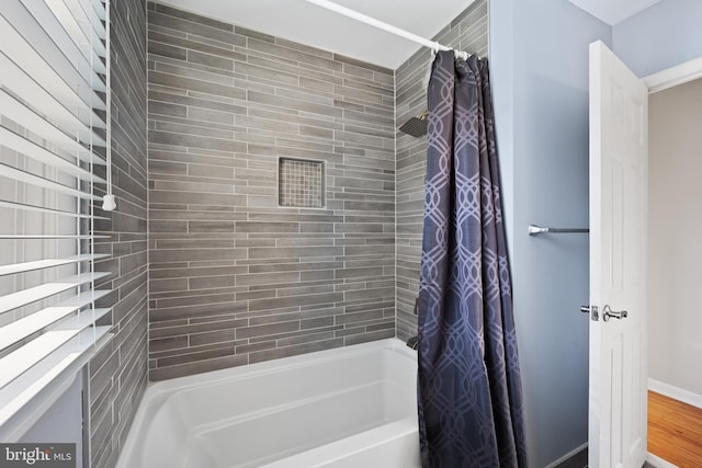 bathroom featuring wood-type flooring and shower / bath combo