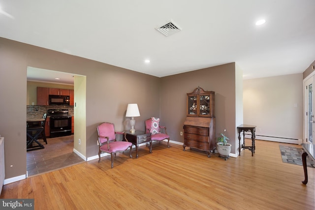 sitting room with light hardwood / wood-style flooring and baseboard heating