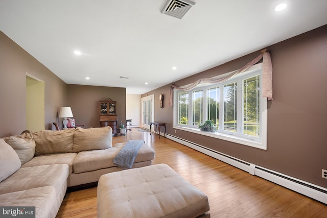 living room with a baseboard radiator and light wood-type flooring