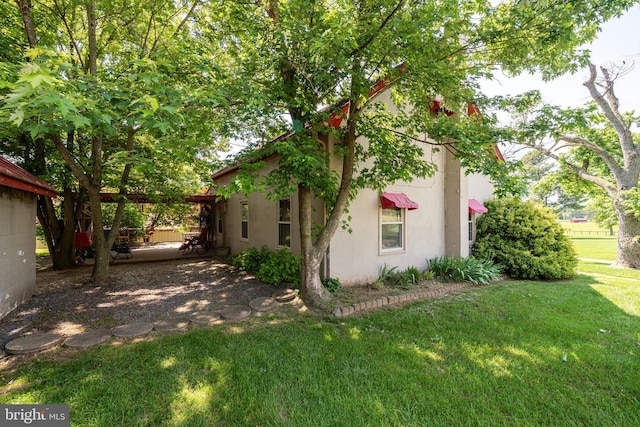 view of side of home with a lawn