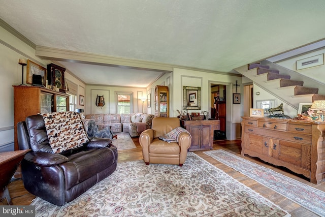 living room featuring hardwood / wood-style floors, a textured ceiling, and crown molding