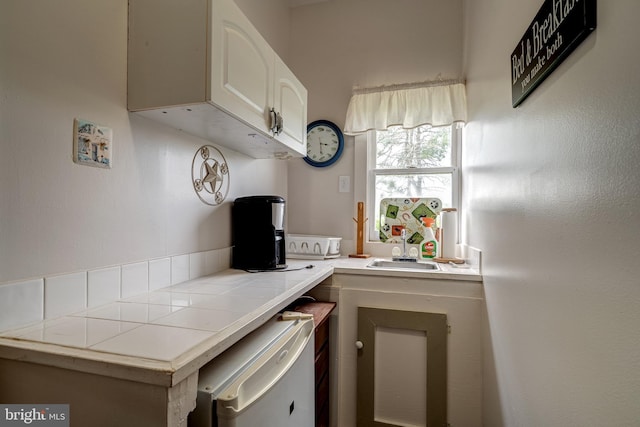 kitchen featuring tile countertops, sink, white cabinets, and white refrigerator