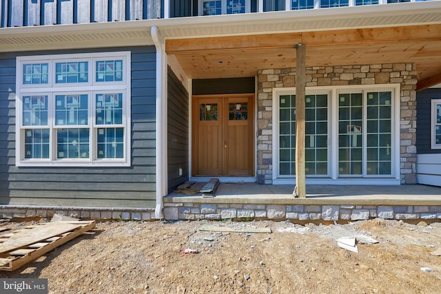 entrance to property featuring board and batten siding and stone siding