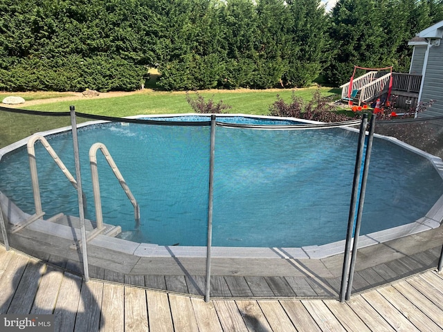 view of pool with a lawn