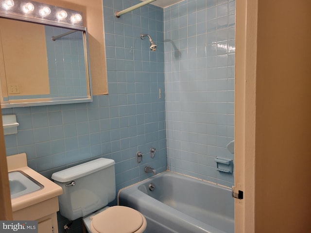 full bathroom with tiled shower / bath, vanity, and toilet