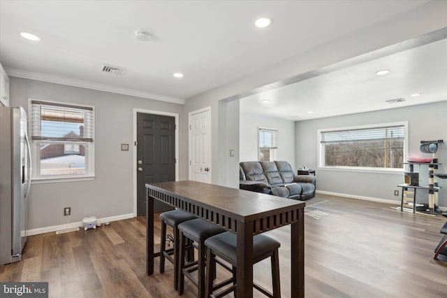 dining area with dark hardwood / wood-style floors and crown molding