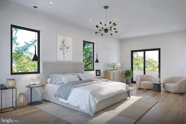 bedroom featuring multiple windows, an inviting chandelier, and light wood-type flooring