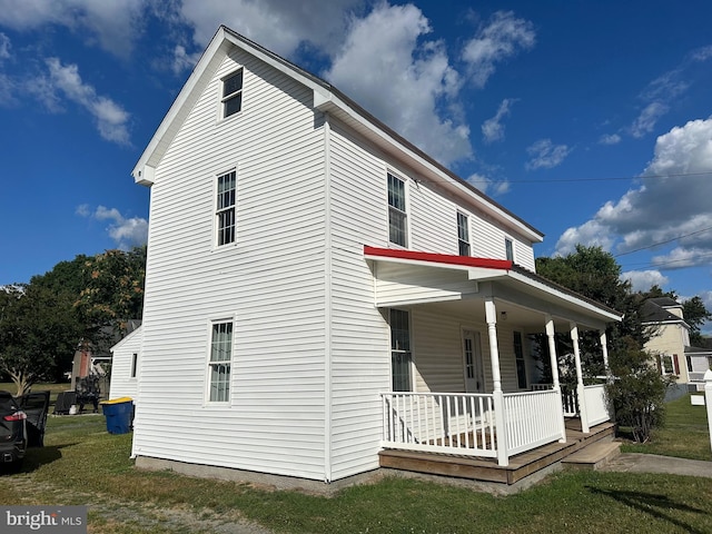 view of home's exterior with a lawn and covered porch