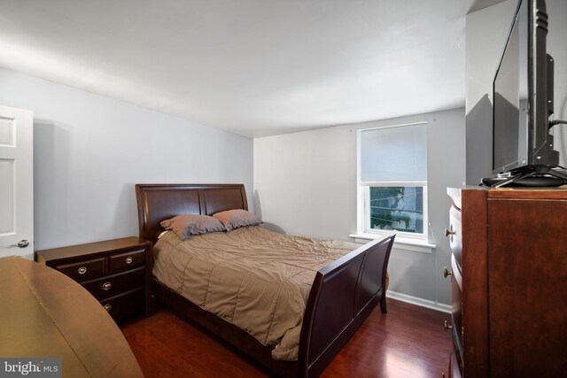 bedroom with dark hardwood / wood-style flooring