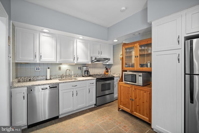 kitchen with white cabinets, decorative backsplash, stainless steel appliances, and sink