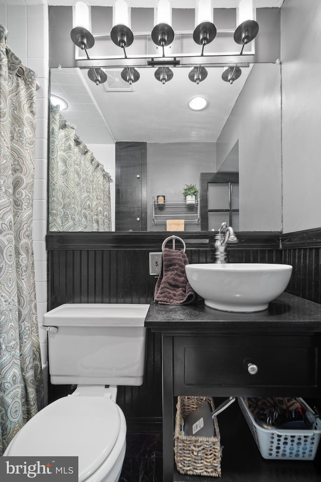 bathroom with curtained shower, vanity, and toilet