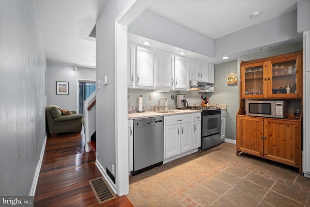 kitchen with sink, white cabinets, wood-type flooring, and appliances with stainless steel finishes