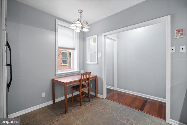 home office with dark hardwood / wood-style flooring and a notable chandelier