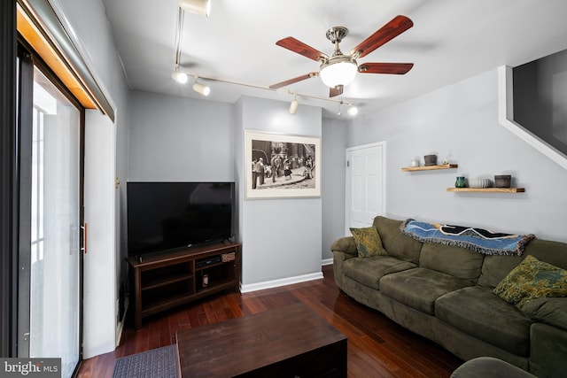 living room with ceiling fan, rail lighting, and dark wood-type flooring