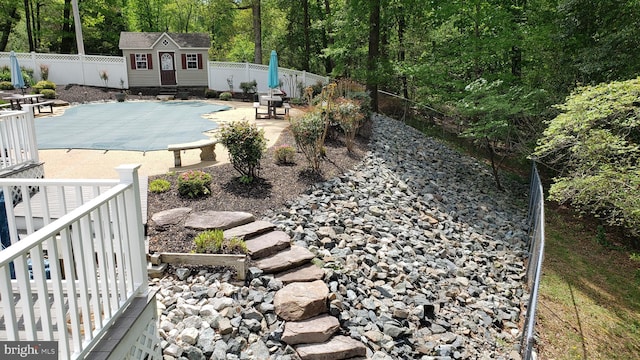 view of pool with an outbuilding and a patio