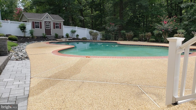 view of swimming pool featuring an outbuilding and a patio area