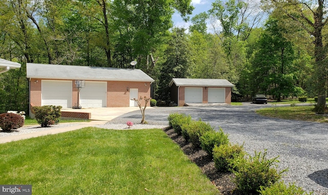 ranch-style home featuring an outdoor structure, a garage, and a front yard