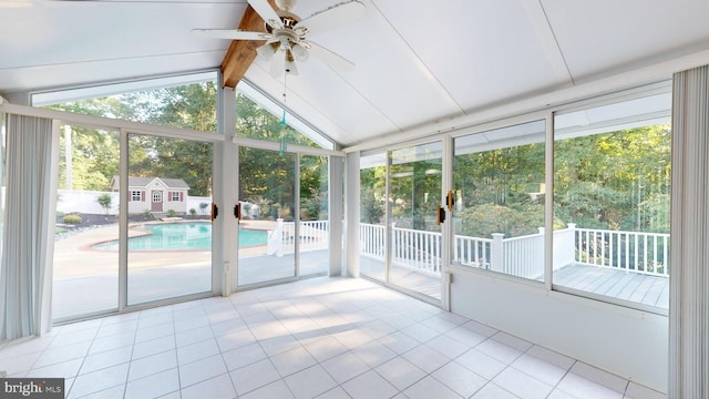 unfurnished sunroom featuring ceiling fan and vaulted ceiling with beams