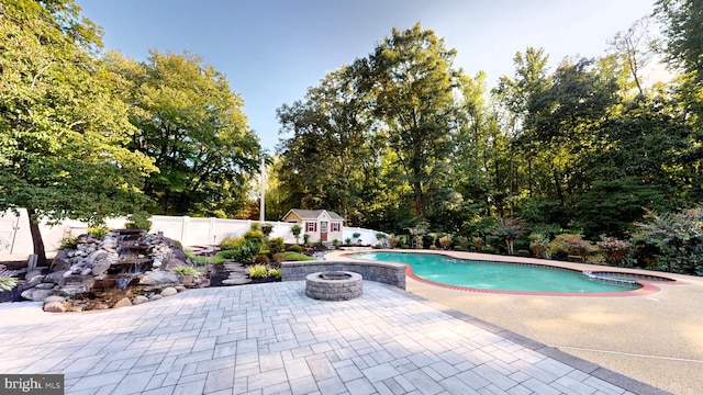 view of pool with an outdoor fire pit and a patio