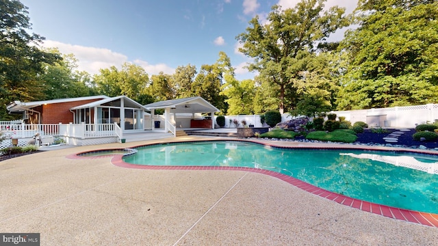 view of pool featuring a sunroom and a patio