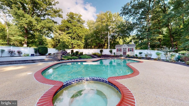 view of pool with a patio area and an in ground hot tub