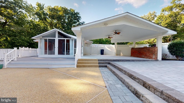 back of property with ceiling fan, a patio area, and a sunroom