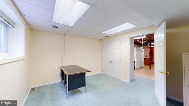 interior space with a paneled ceiling and carpet