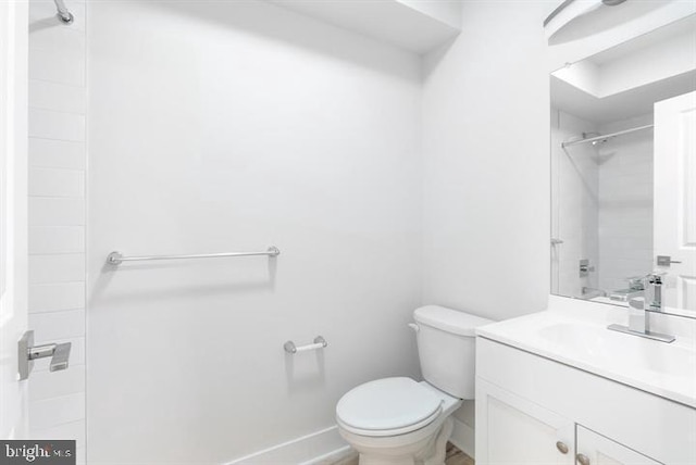 bathroom featuring tiled shower, vanity, and toilet