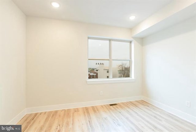 spare room featuring a wealth of natural light and light hardwood / wood-style flooring