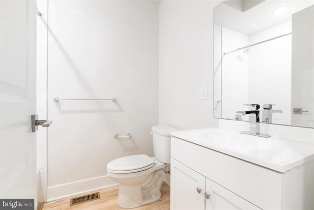 bathroom with vanity, wood-type flooring, and toilet