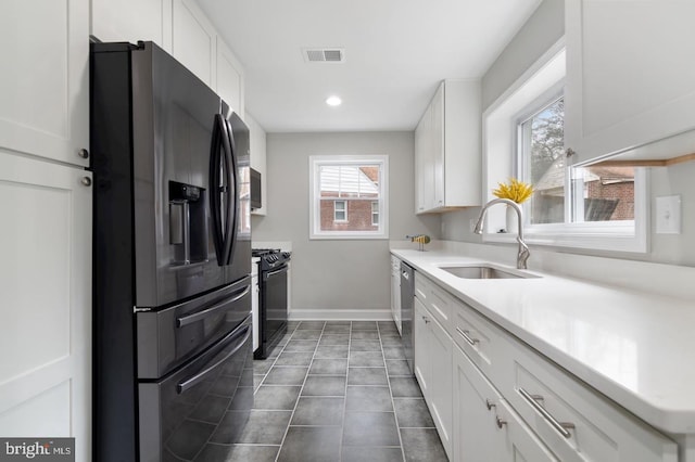 kitchen featuring black appliances, white cabinets, and sink