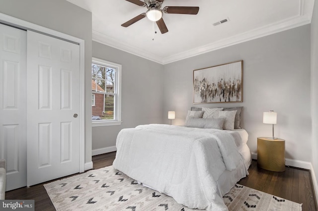 bedroom featuring ceiling fan, ornamental molding, dark wood-type flooring, and a closet