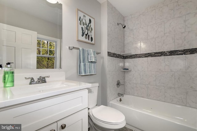 full bathroom with vanity, tiled shower / bath combo, and toilet