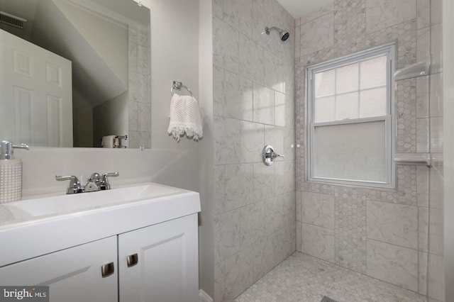 bathroom featuring vanity and tiled shower