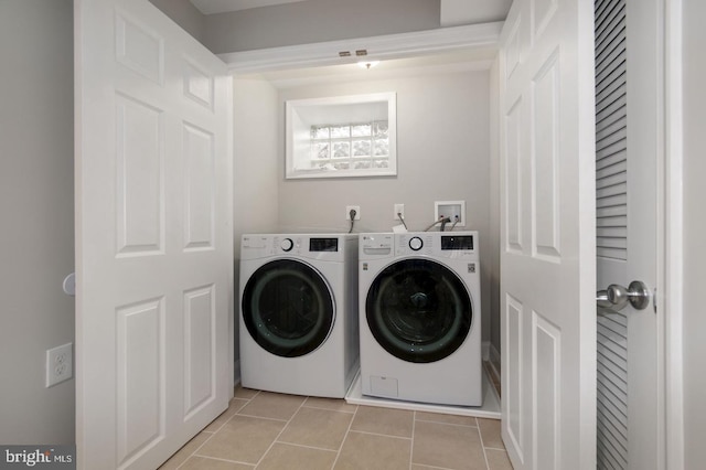 washroom featuring light tile patterned floors and washer and clothes dryer