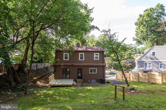 back of house featuring central AC unit and a yard